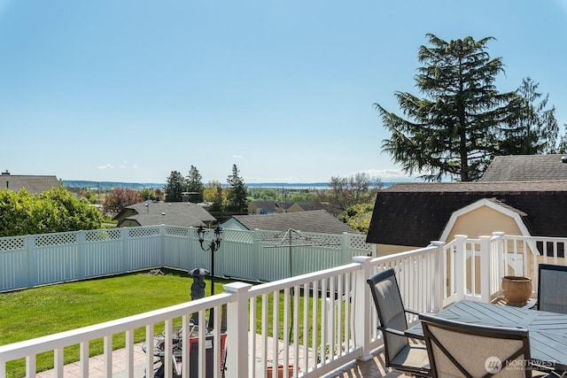 wooden deck with a lawn, a fenced backyard, a storage shed, and an outdoor structure