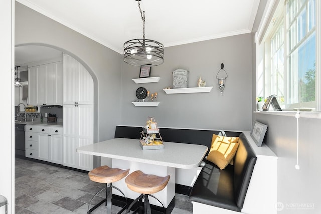 dining space with arched walkways and ornamental molding