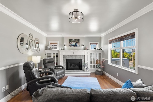 living room with crown molding, baseboards, wood finished floors, and a premium fireplace