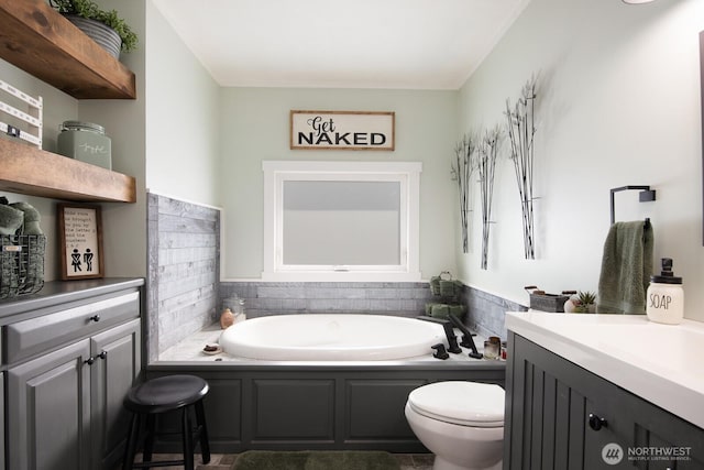 bathroom with vanity, a bath, and toilet