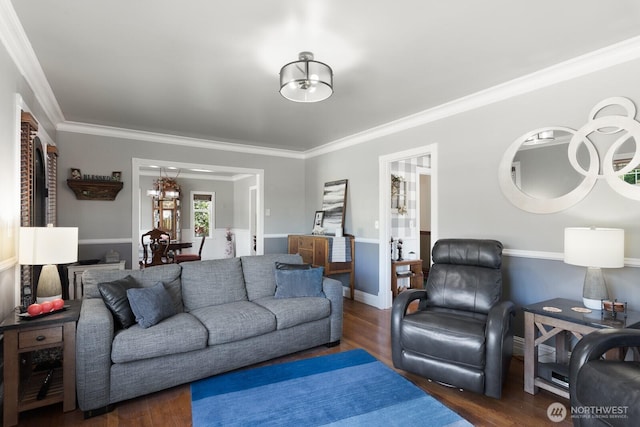 living area with ornamental molding, wood finished floors, and a notable chandelier