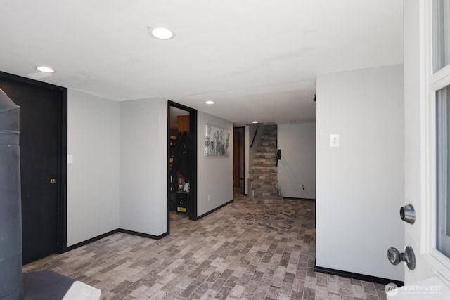 finished below grade area with stairway, baseboards, and recessed lighting
