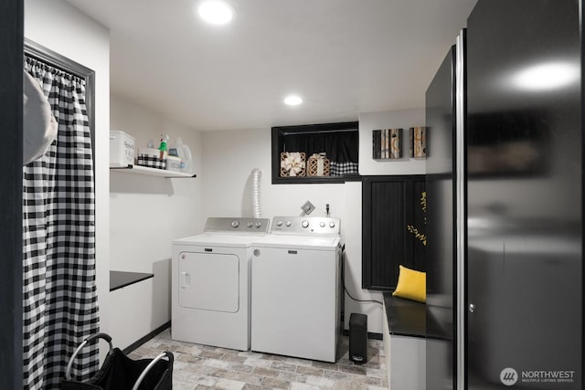 laundry area with washing machine and clothes dryer, recessed lighting, laundry area, and stone finish flooring