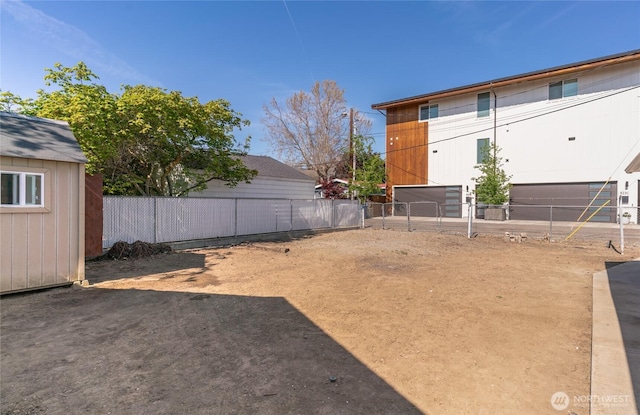 view of yard featuring a storage unit, fence, and an outbuilding