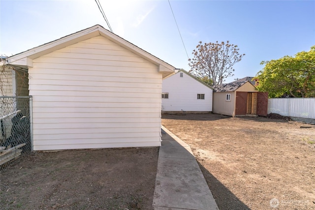 view of property exterior featuring a storage unit, a fenced backyard, and an outdoor structure