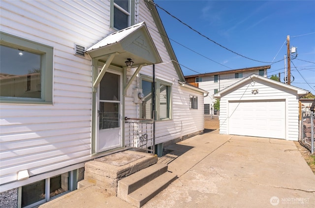 view of property exterior featuring a garage, an outdoor structure, and driveway