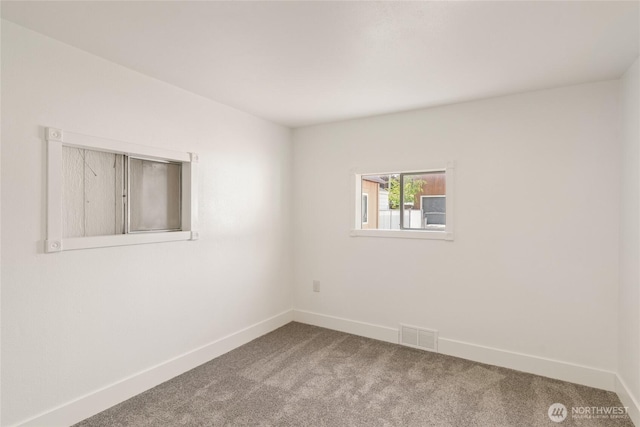 carpeted spare room featuring visible vents and baseboards