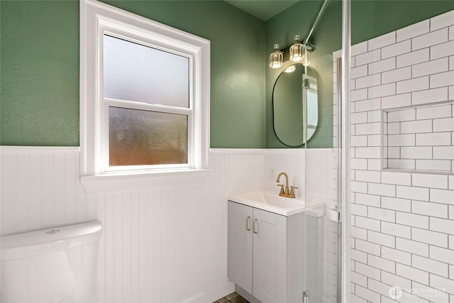 bathroom featuring vanity, toilet, and wainscoting