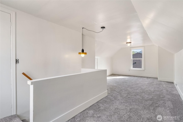 bonus room featuring lofted ceiling, carpet flooring, and baseboards