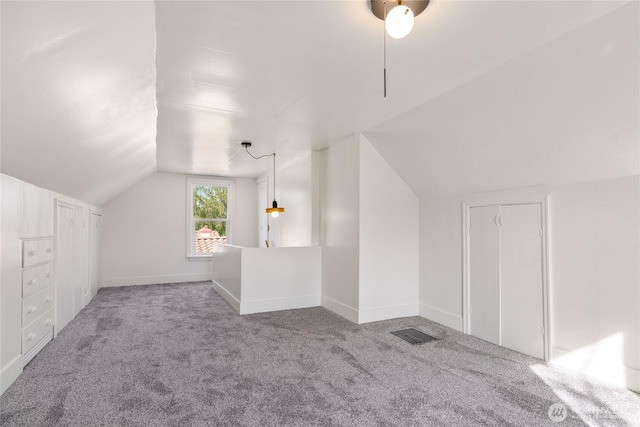 bonus room featuring baseboards, lofted ceiling, and carpet flooring