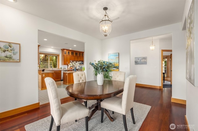 dining space with baseboards, dark wood-style floors, a chandelier, and recessed lighting