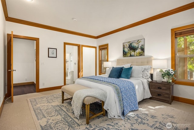 bedroom with carpet flooring, baseboards, crown molding, and connected bathroom