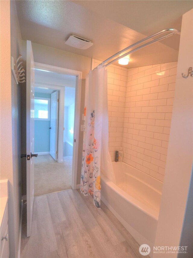 full bathroom with vanity, wood finished floors, and shower / bath combo