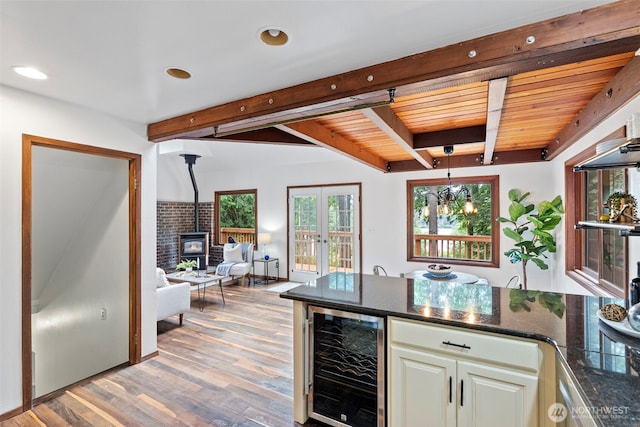 13600 Hillcrest St NW, Poulsbo, WA 98370 - indoor bar featuring wine cooler, a wood stove, light wood-type flooring, recessed lighting, and hanging light fixtures