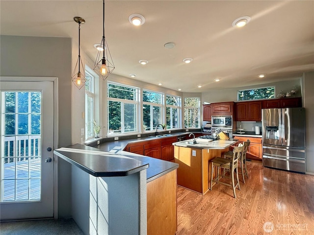 168 Jackson Rd, Orcas Island, WA 98245 - kitchen featuring appliances with stainless steel finishes, a sink, a breakfast bar, recessed lighting, and light wood-style flooring