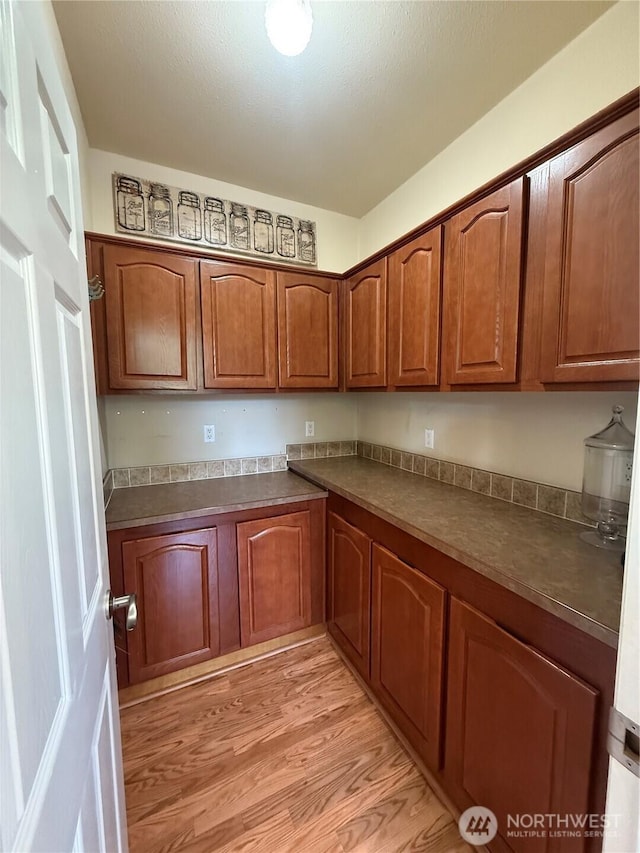 168 Jackson Rd, Orcas Island, WA 98245 - kitchen with light wood finished floors, brown cabinetry, and dark countertops