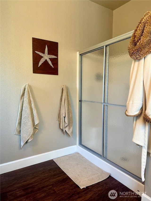 168 Jackson Rd, Orcas Island, WA 98245 - full bathroom with wood finished floors, a stall shower, and baseboards