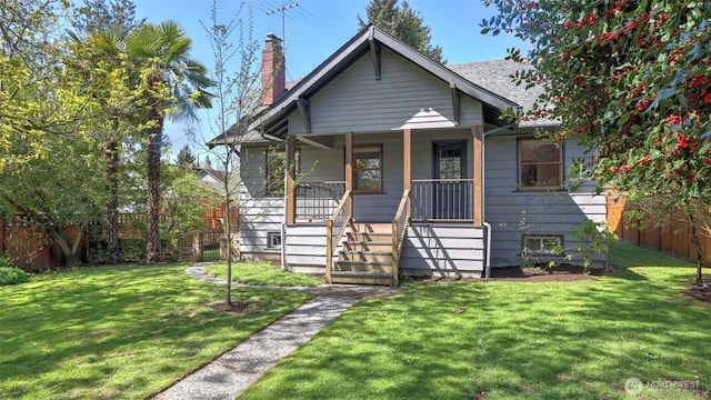 bungalow featuring a front yard, a chimney, covered porch, and fence