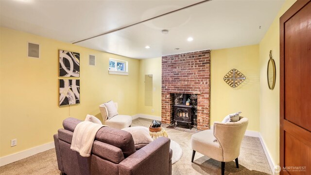 living room with recessed lighting, baseboards, a wood stove, and light colored carpet