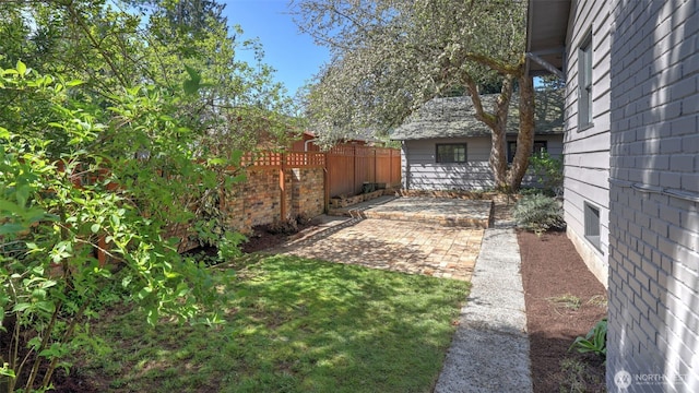view of yard with fence and a patio
