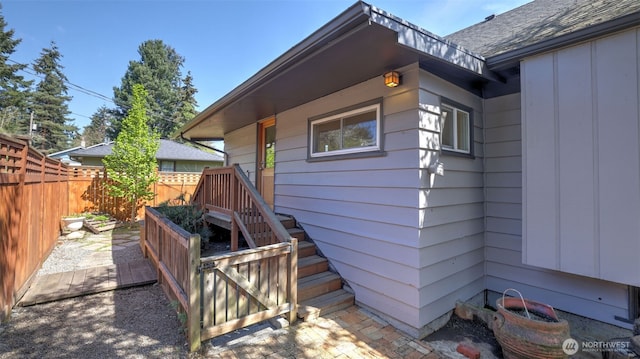 view of home's exterior with board and batten siding and fence