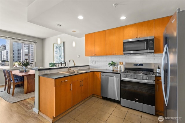 76 Cedar St Unit Ph07, Seattle, WA 98121 - kitchen featuring stainless steel appliances, a peninsula, decorative backsplash, dark countertops, and decorative light fixtures