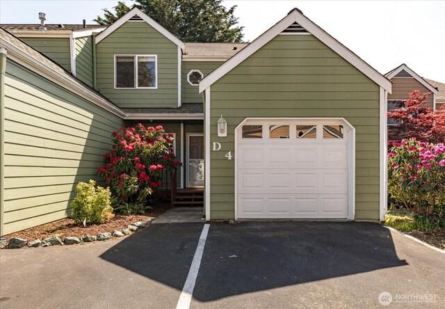 view of front of property with driveway and a shingled roof