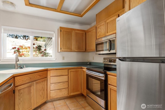 kitchen with appliances with stainless steel finishes, light tile patterned floors, and a sink