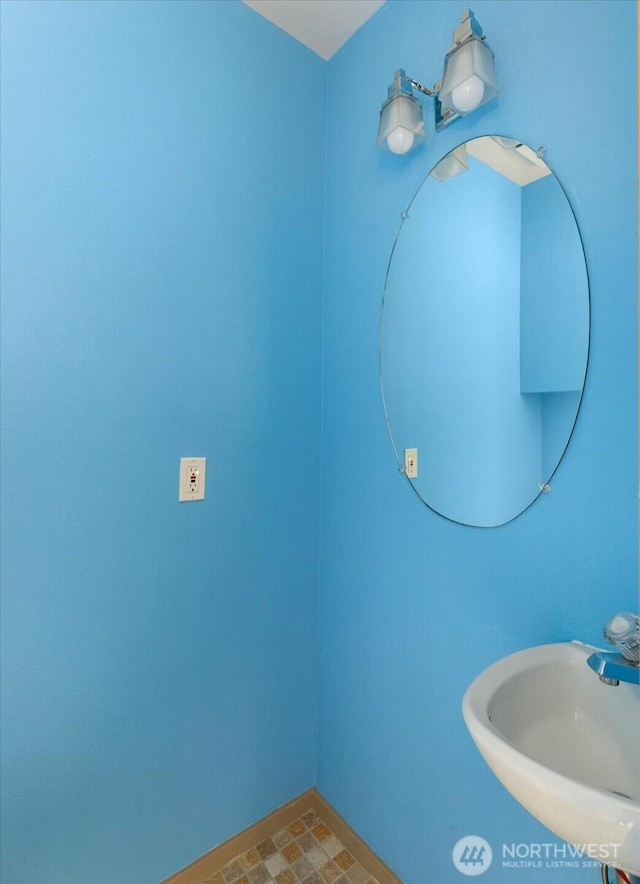 bathroom featuring a sink and baseboards