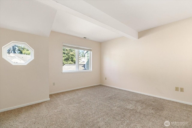 carpeted spare room with beam ceiling, baseboards, and visible vents
