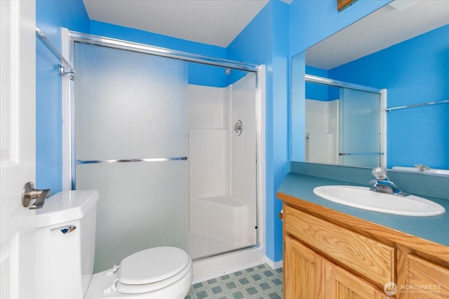 full bathroom featuring tile patterned floors, toilet, vanity, and a shower stall