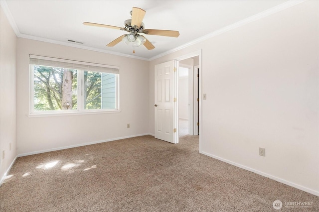 empty room with carpet, visible vents, crown molding, and baseboards