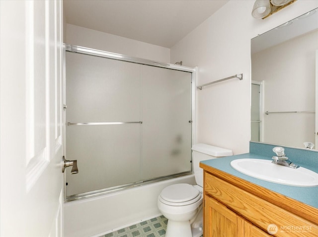 bathroom with toilet, vanity, and shower / bath combination with glass door