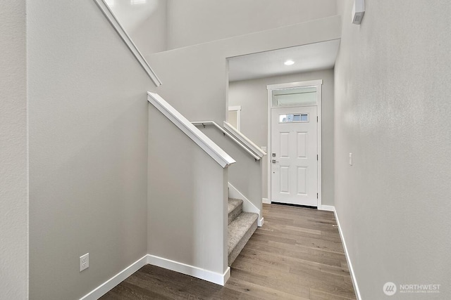 foyer with stairway, wood finished floors, and baseboards