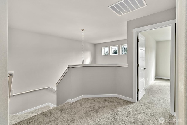 interior space with visible vents, carpet, and baseboards