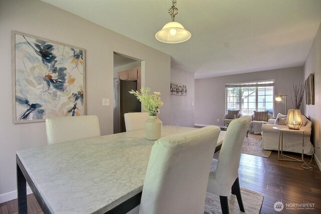 dining space with dark wood finished floors and baseboards