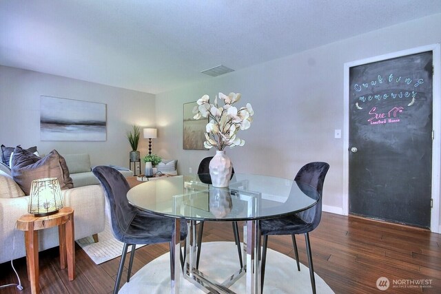 dining area featuring baseboards, wood finished floors, and visible vents