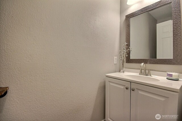 bathroom featuring a textured wall and vanity