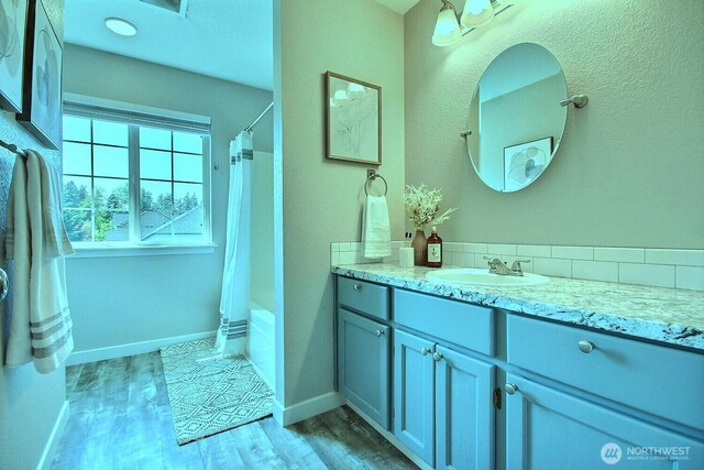 bathroom featuring baseboards, a shower with curtain, vanity, and wood finished floors