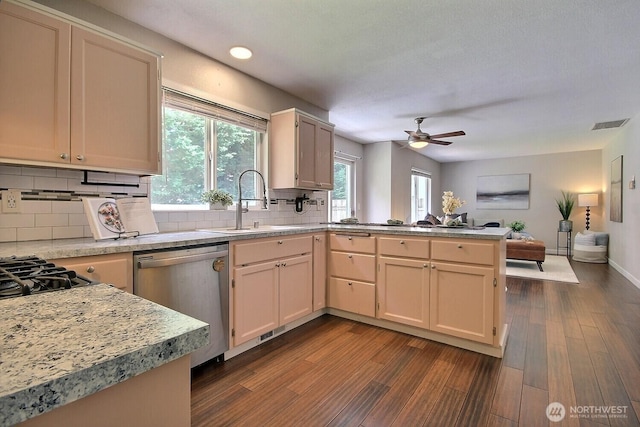 kitchen featuring a sink, open floor plan, dark wood-style flooring, dishwasher, and a peninsula
