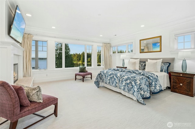 bedroom with ornamental molding, carpet flooring, a glass covered fireplace, and recessed lighting