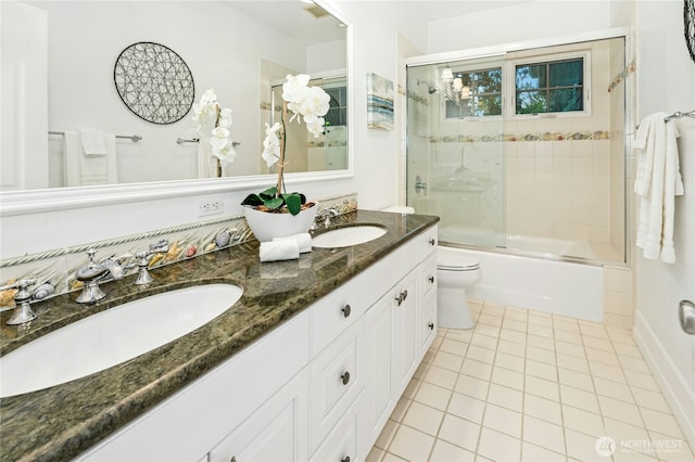bathroom with double vanity, tile patterned floors, toilet, and a sink