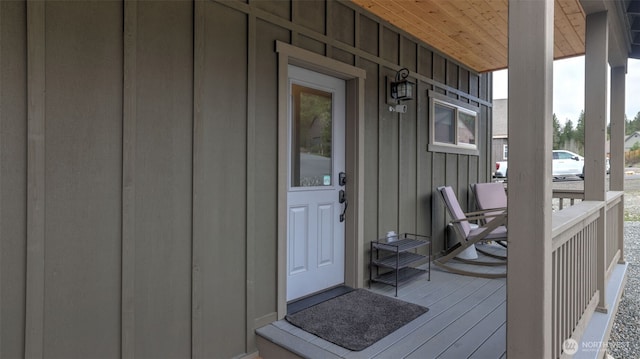 view of exterior entry with covered porch and board and batten siding