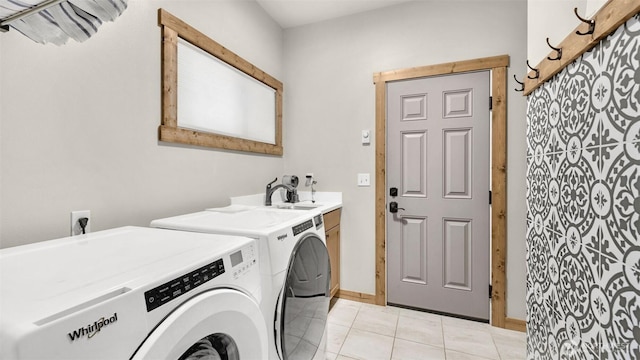 clothes washing area with baseboards, a sink, cabinet space, independent washer and dryer, and light tile patterned floors