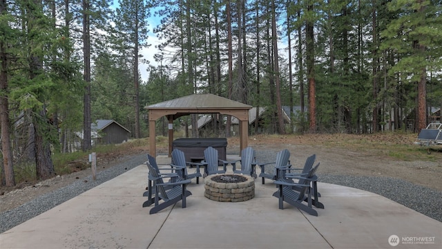 view of patio featuring a gazebo, a hot tub, and an outdoor fire pit