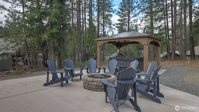 view of patio / terrace featuring a gazebo, a hot tub, and a fire pit