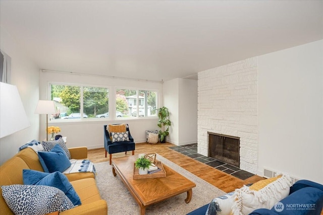 living area featuring wood finished floors, a fireplace, and baseboards