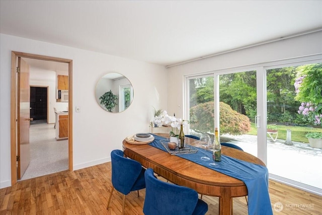 dining area with baseboards and light wood-style floors
