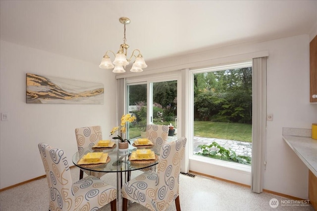 dining area featuring a chandelier and baseboards