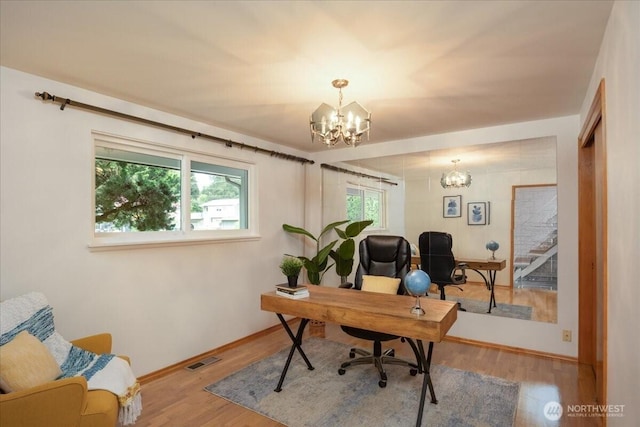 office area featuring a chandelier, wood finished floors, and baseboards